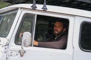 Ein Mann sitzt auf dem Fahrersitz eines weißen Lastwagens