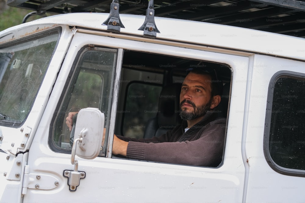 a man sitting in the driver's seat of a white truck