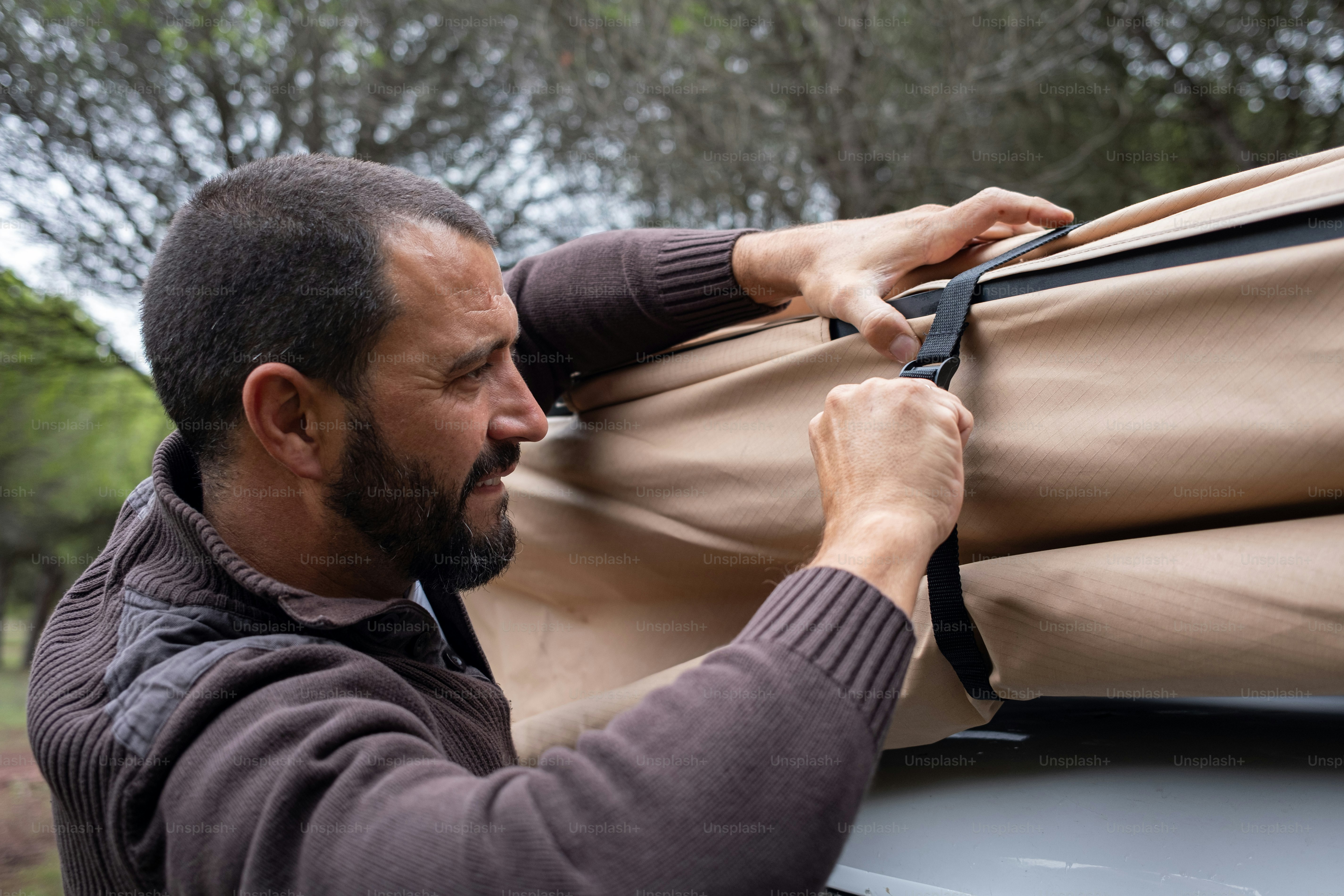 Un hombre con barba sosteniendo una bolsa de equipaje