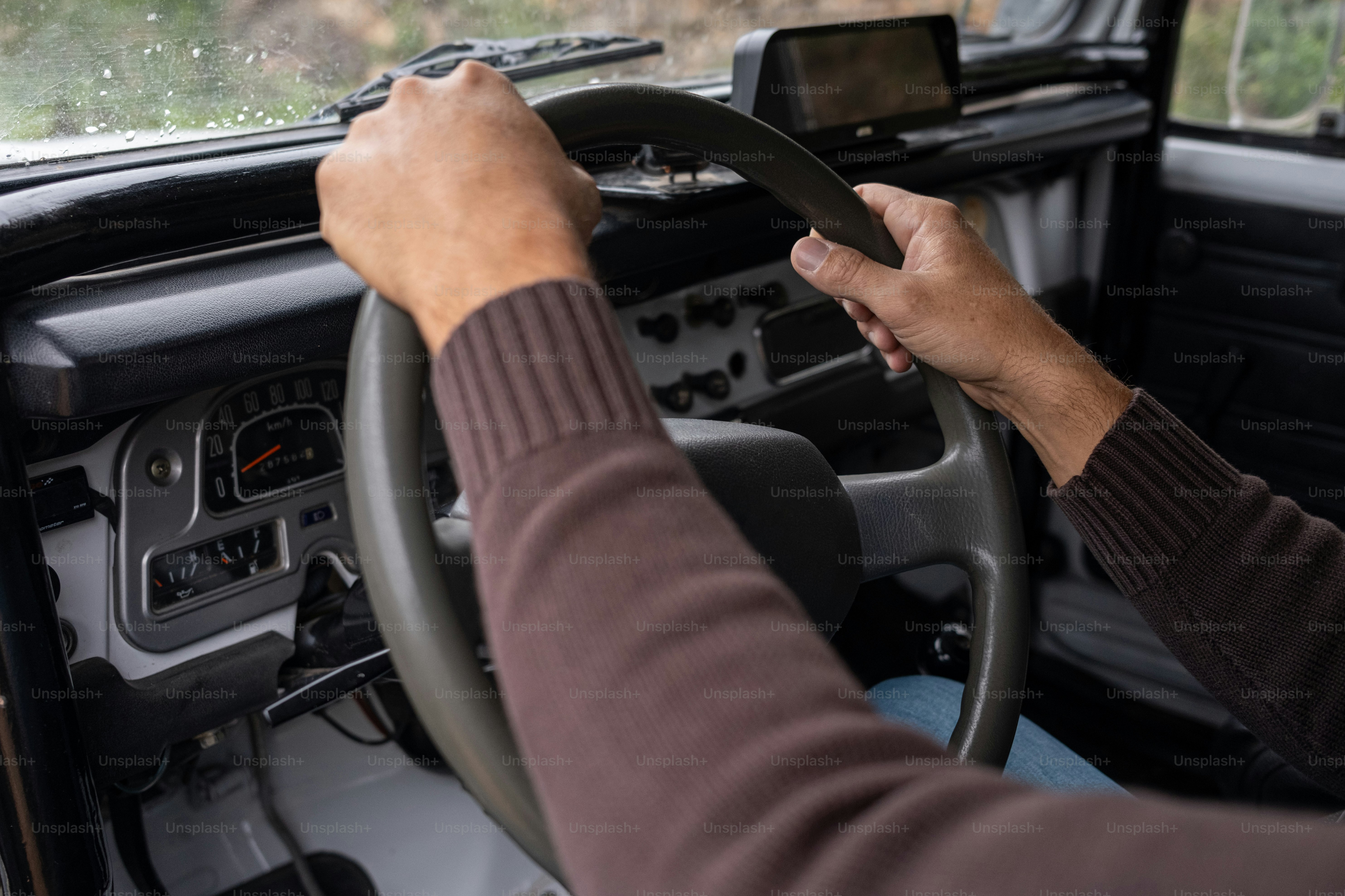 a person driving a car with a steering wheel