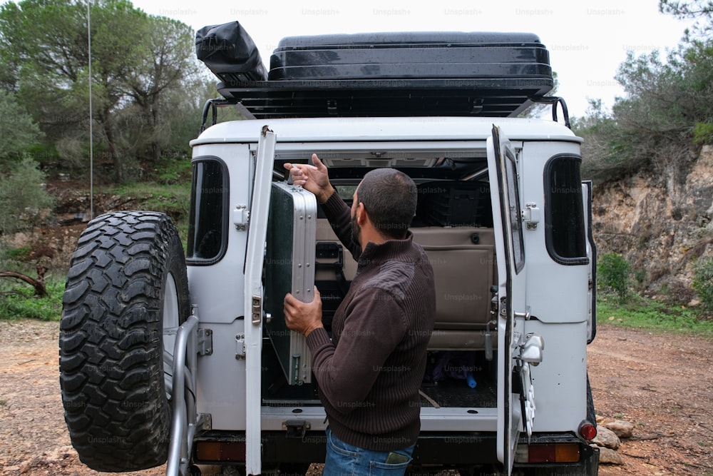 a man opening the door of a white truck