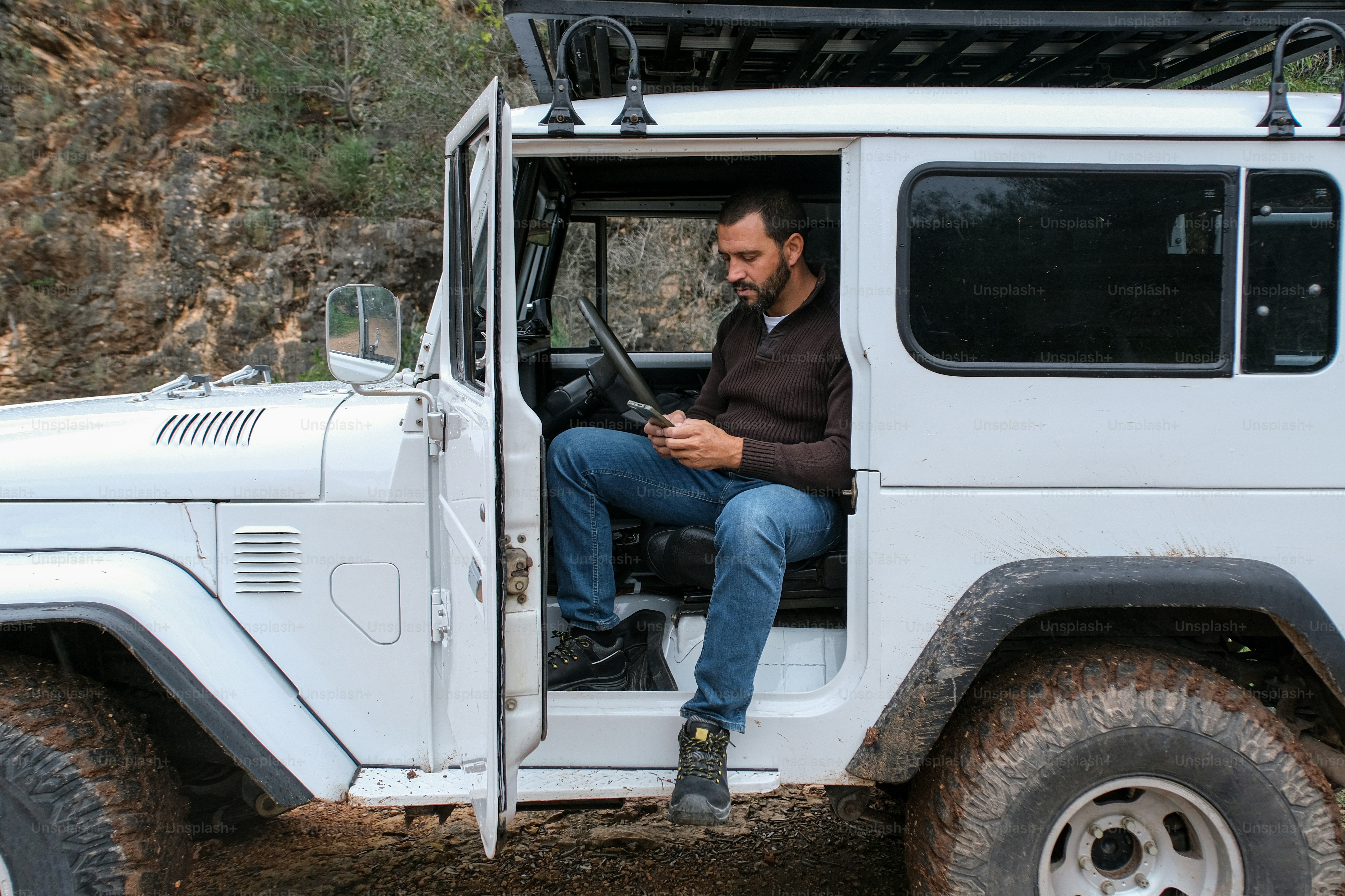 a man sitting in the driver's seat of a white jeep