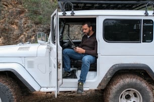a man sitting in the driver's seat of a white jeep