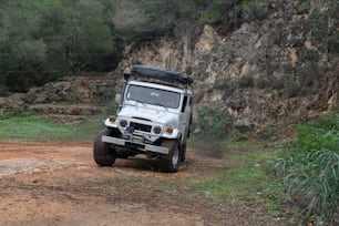 a white jeep driving down a dirt road