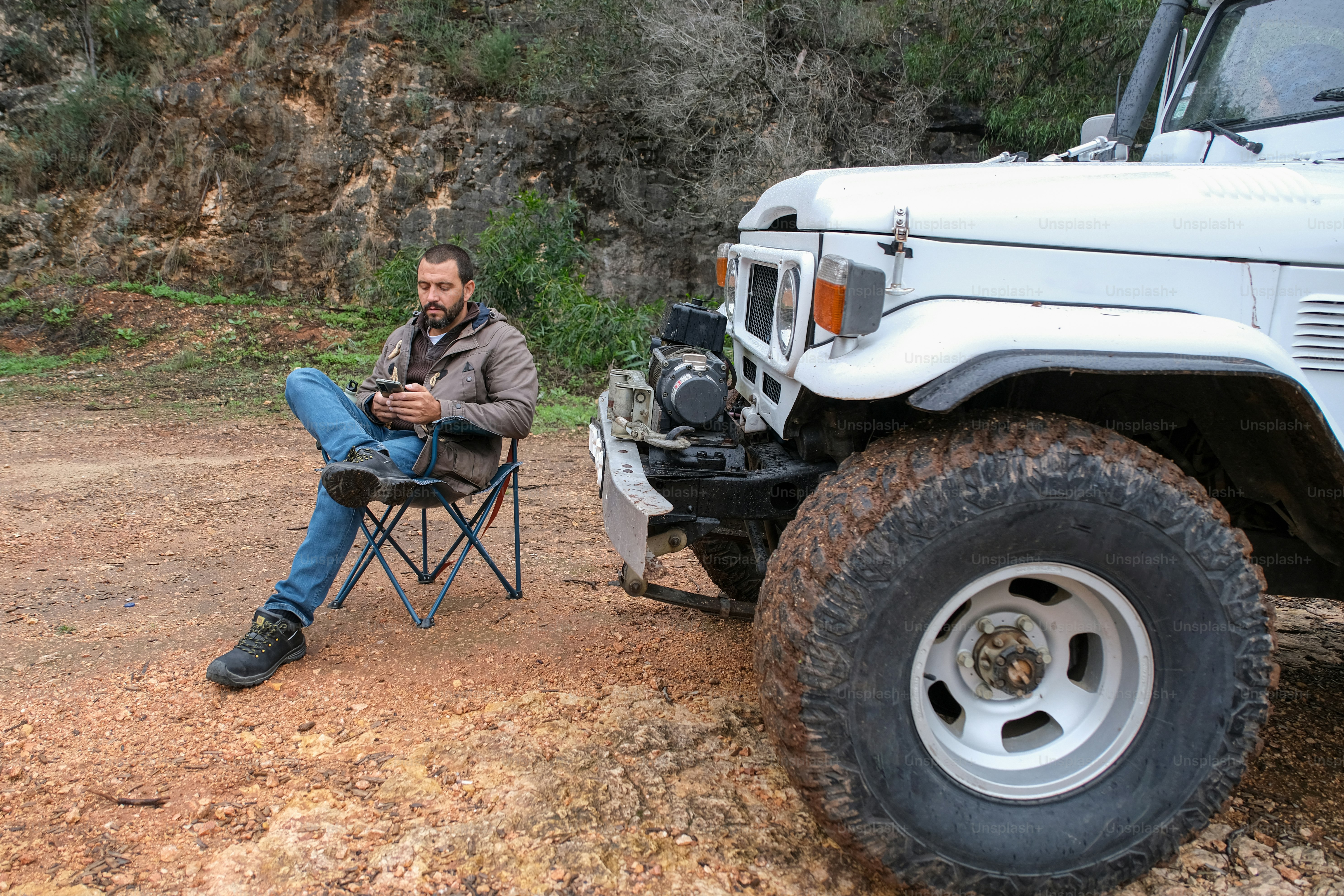 a man sitting in a chair next to a white truck