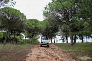 Un jeep conduciendo por un camino de tierra en el bosque