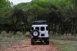 a white jeep driving down a dirt road