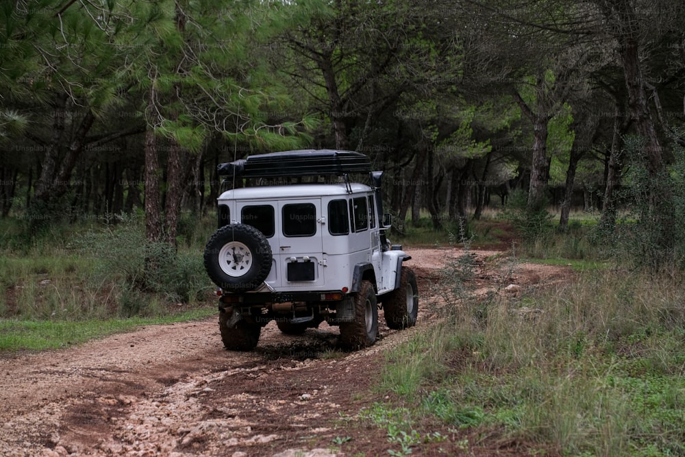 a white jeep driving down a dirt road