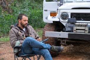 a man sitting in a chair in front of a truck