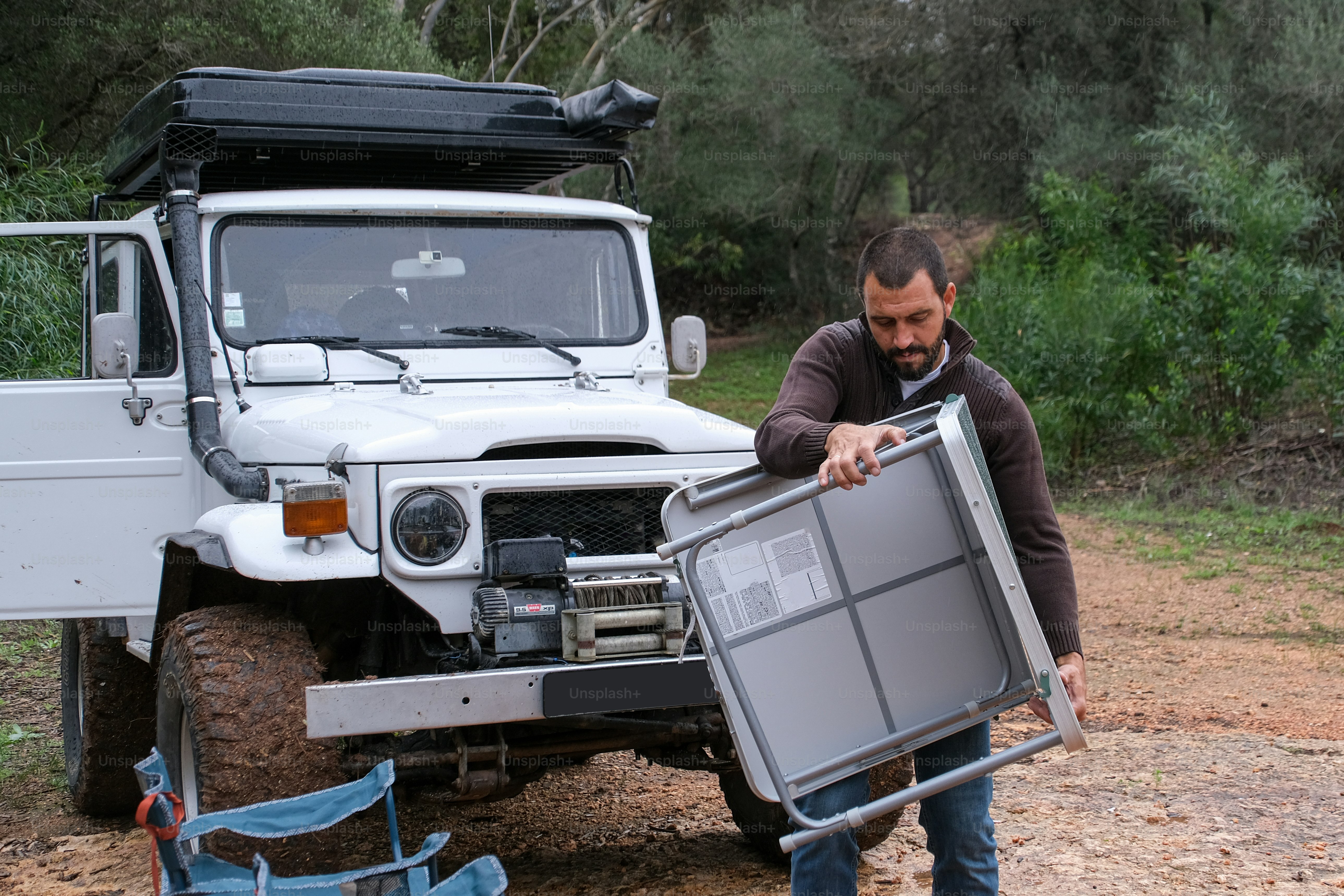 a man holding a large metal box in front of a truck