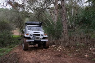 a jeep parked on a dirt road in the woods