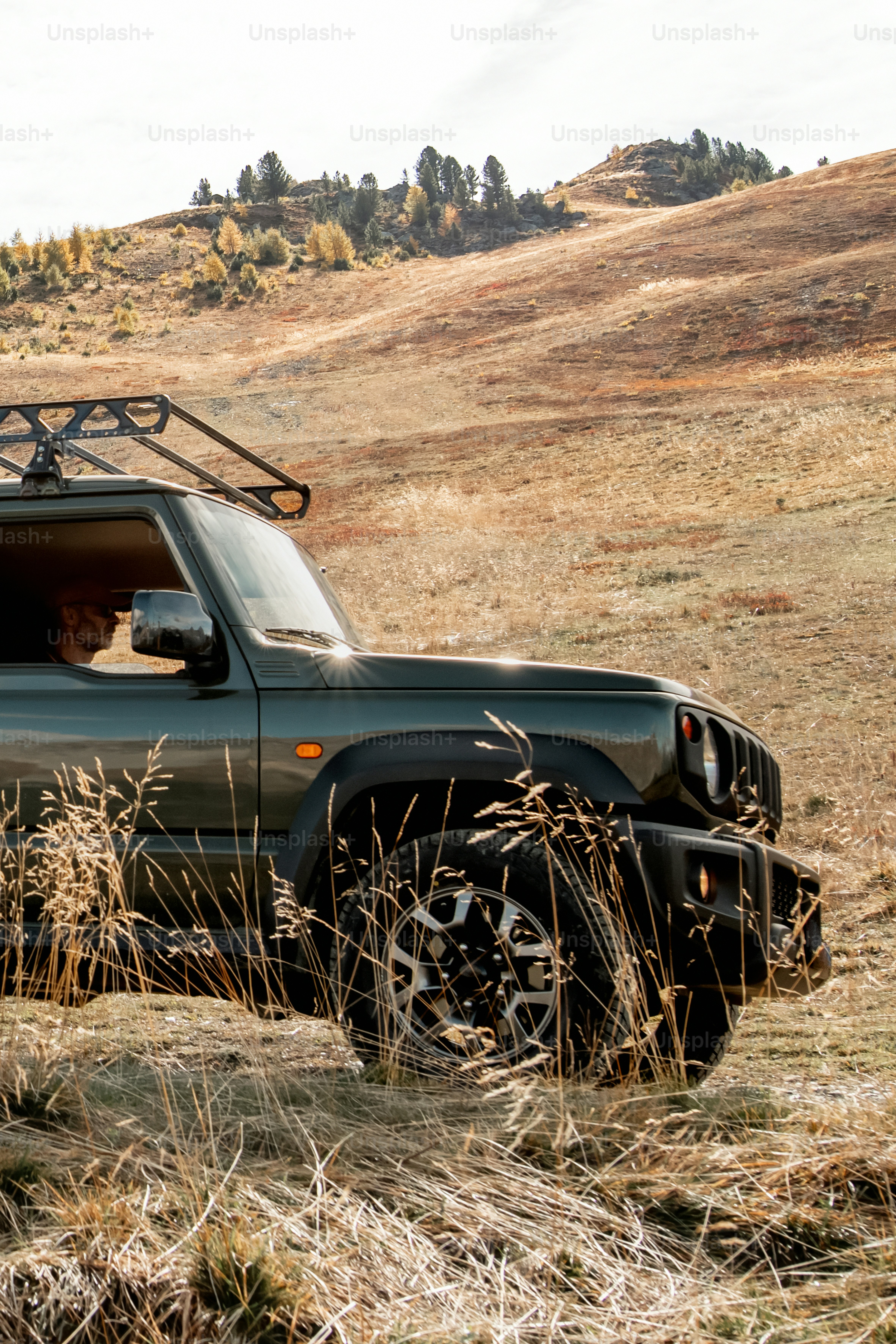 a green truck parked in the middle of a field