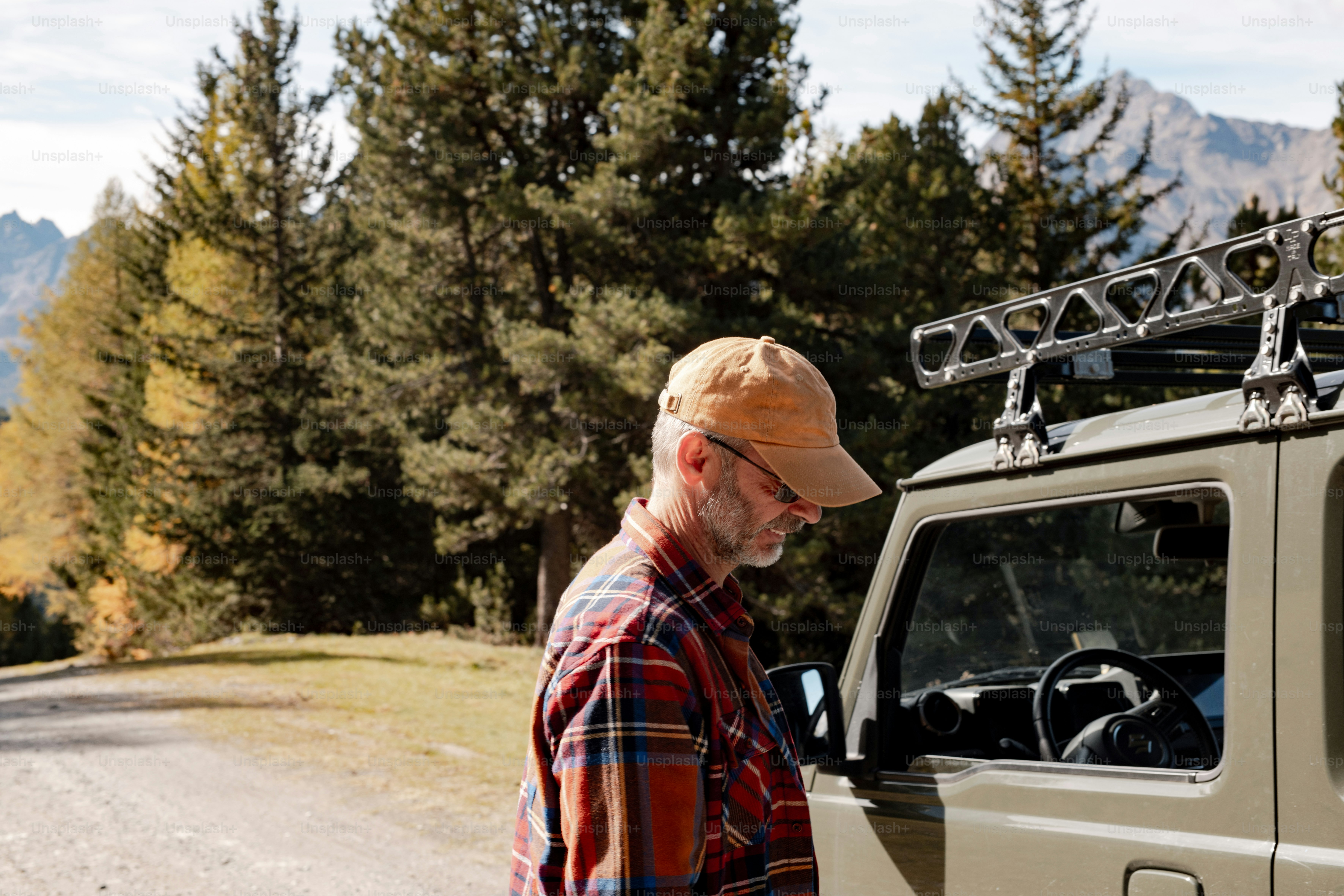 a man standing next to a truck on a dirt road