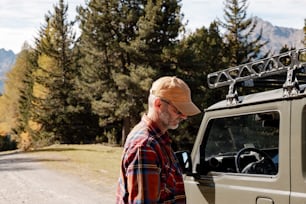 a man standing next to a truck on a dirt road