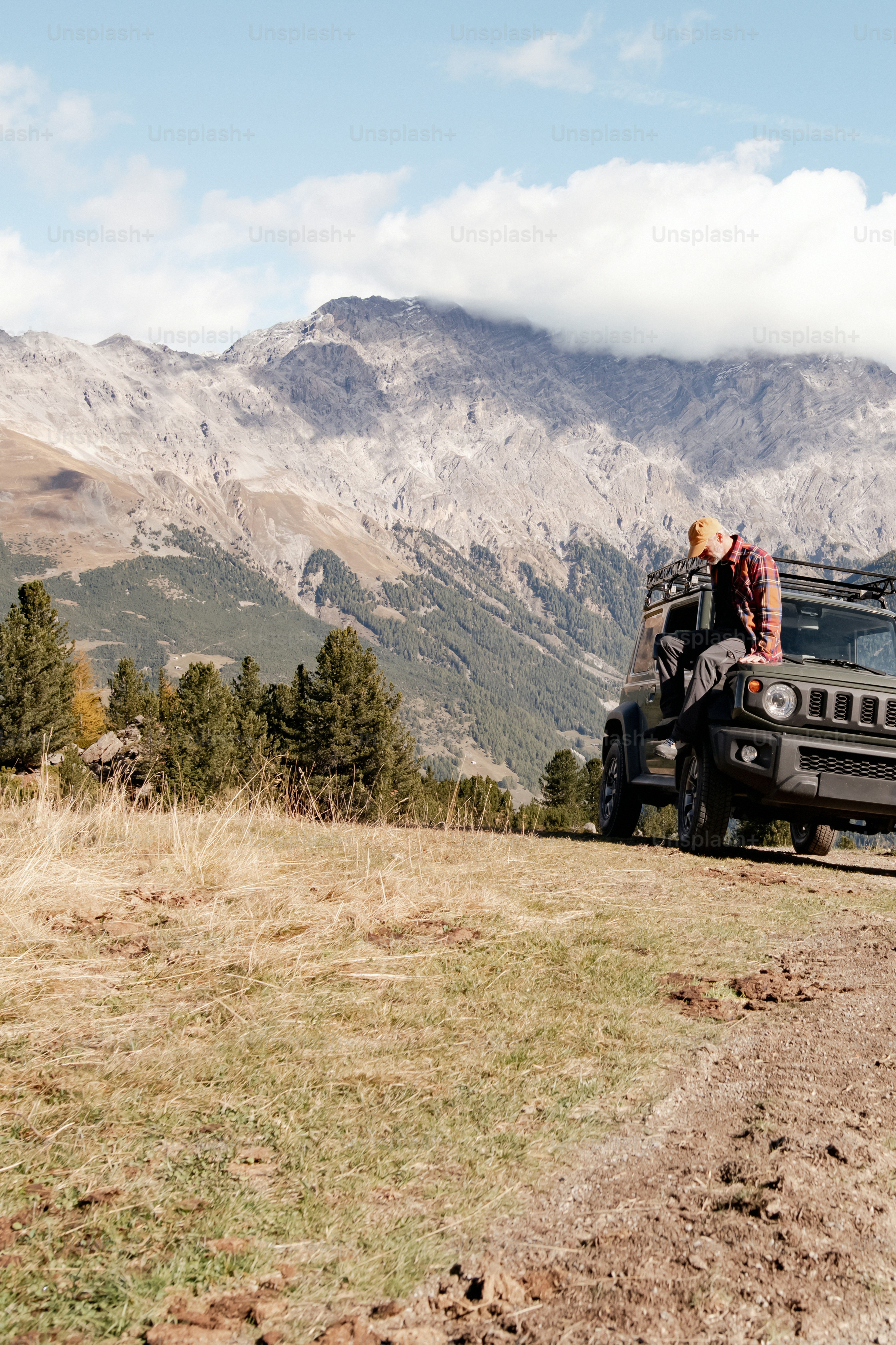 Une jeep est garée sur le bord d’un chemin de terre