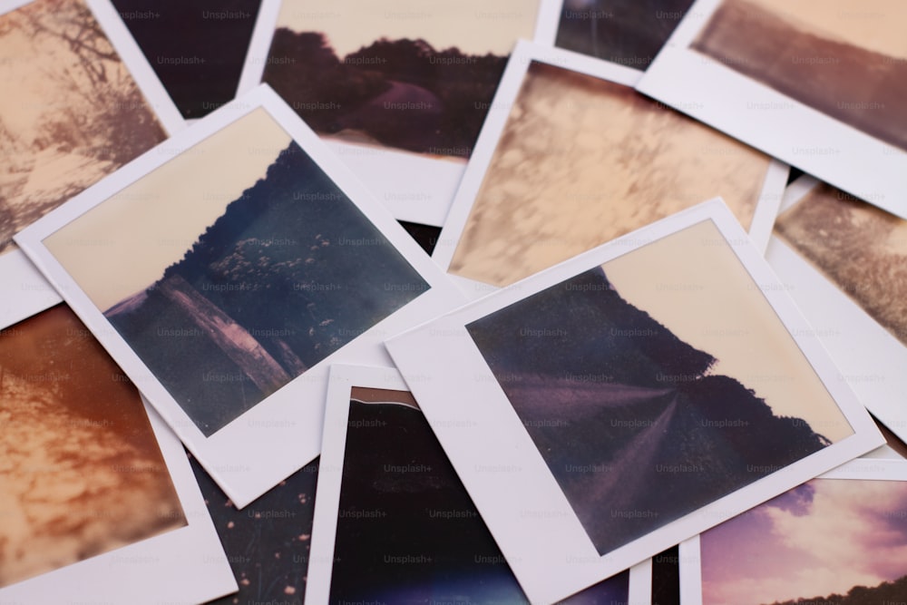 a pile of polaroid pictures sitting on top of a table
