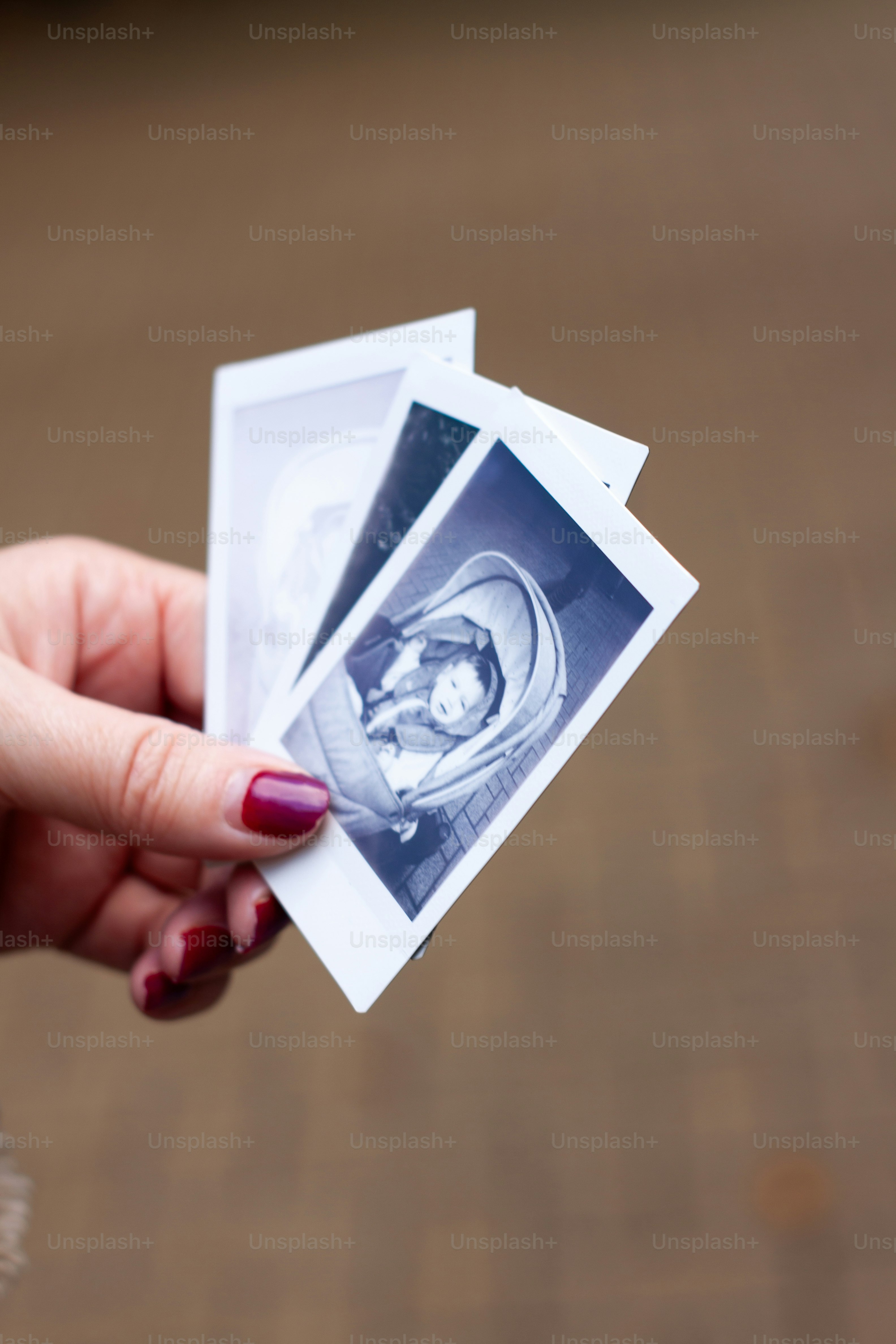 a person holding up three pictures of a baby