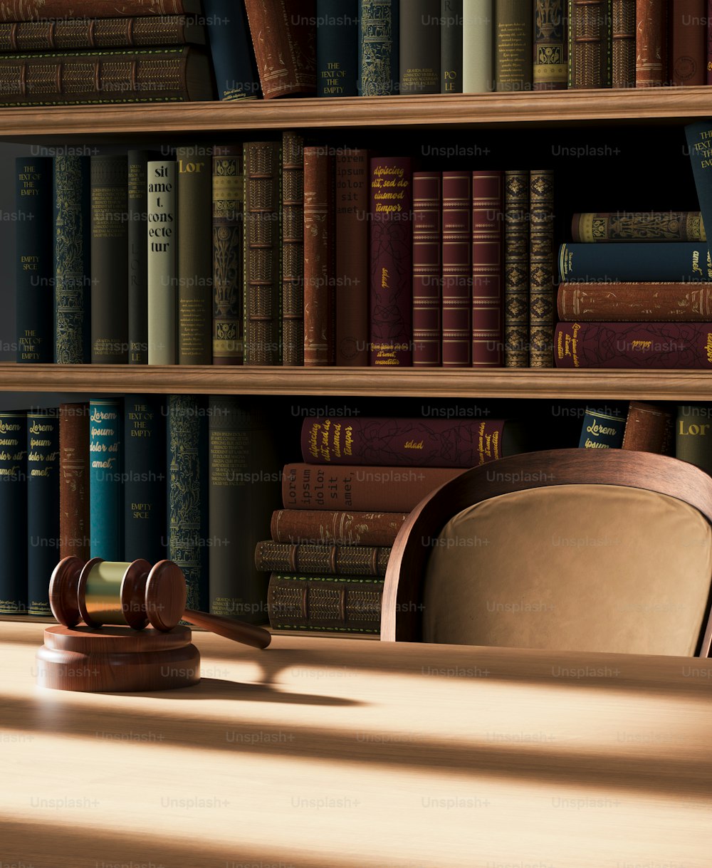 a judge's gavel on a table in front of a bookshelf