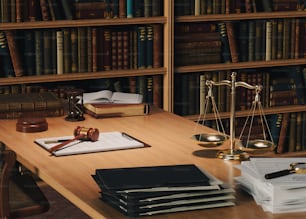 un bureau en bois surmonté de livres et d’une balance de juge