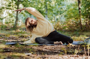 a woman is doing yoga in the woods