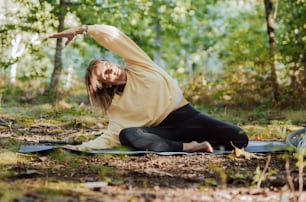 Una mujer está haciendo yoga en el bosque