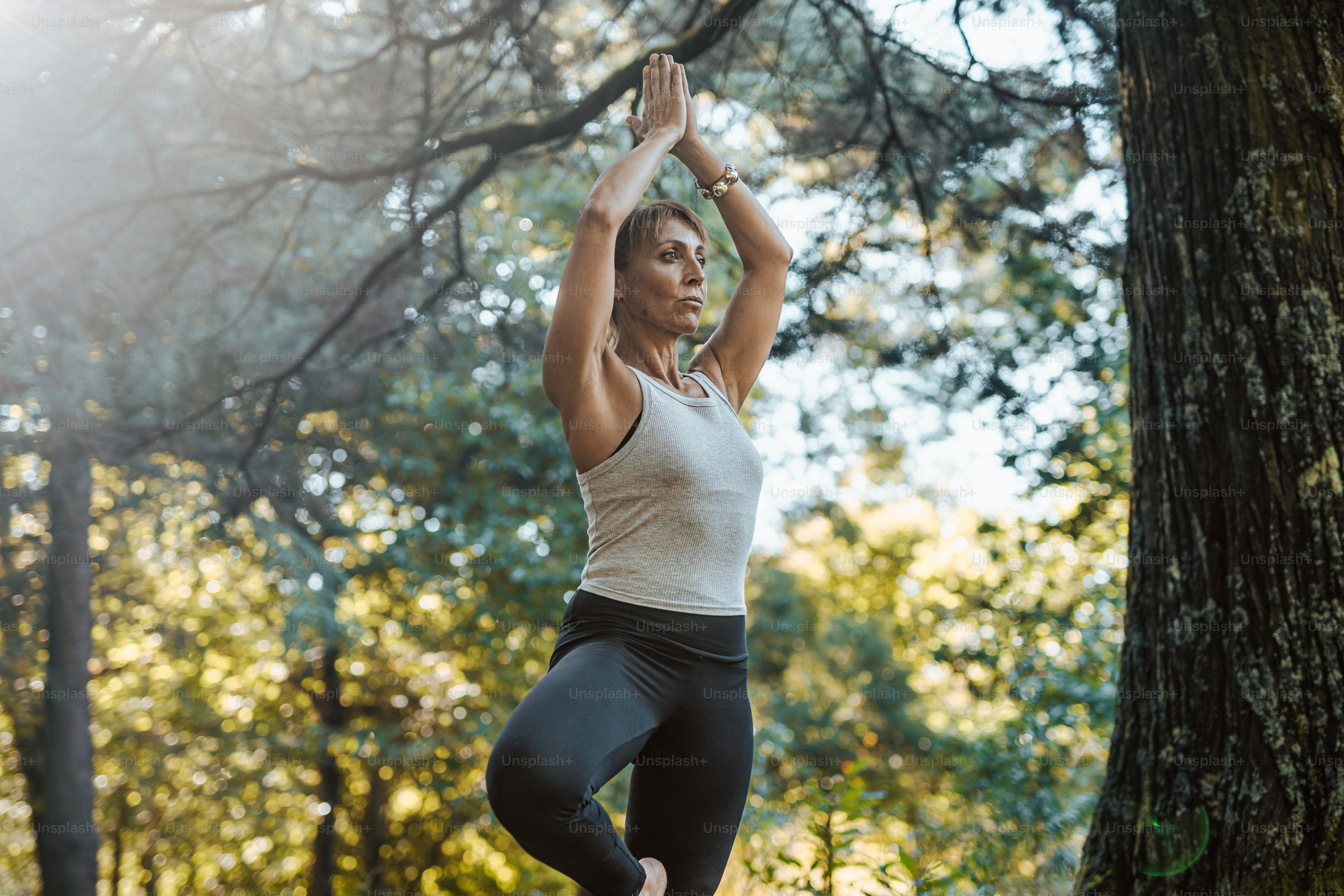 a woman is doing yoga in the woods