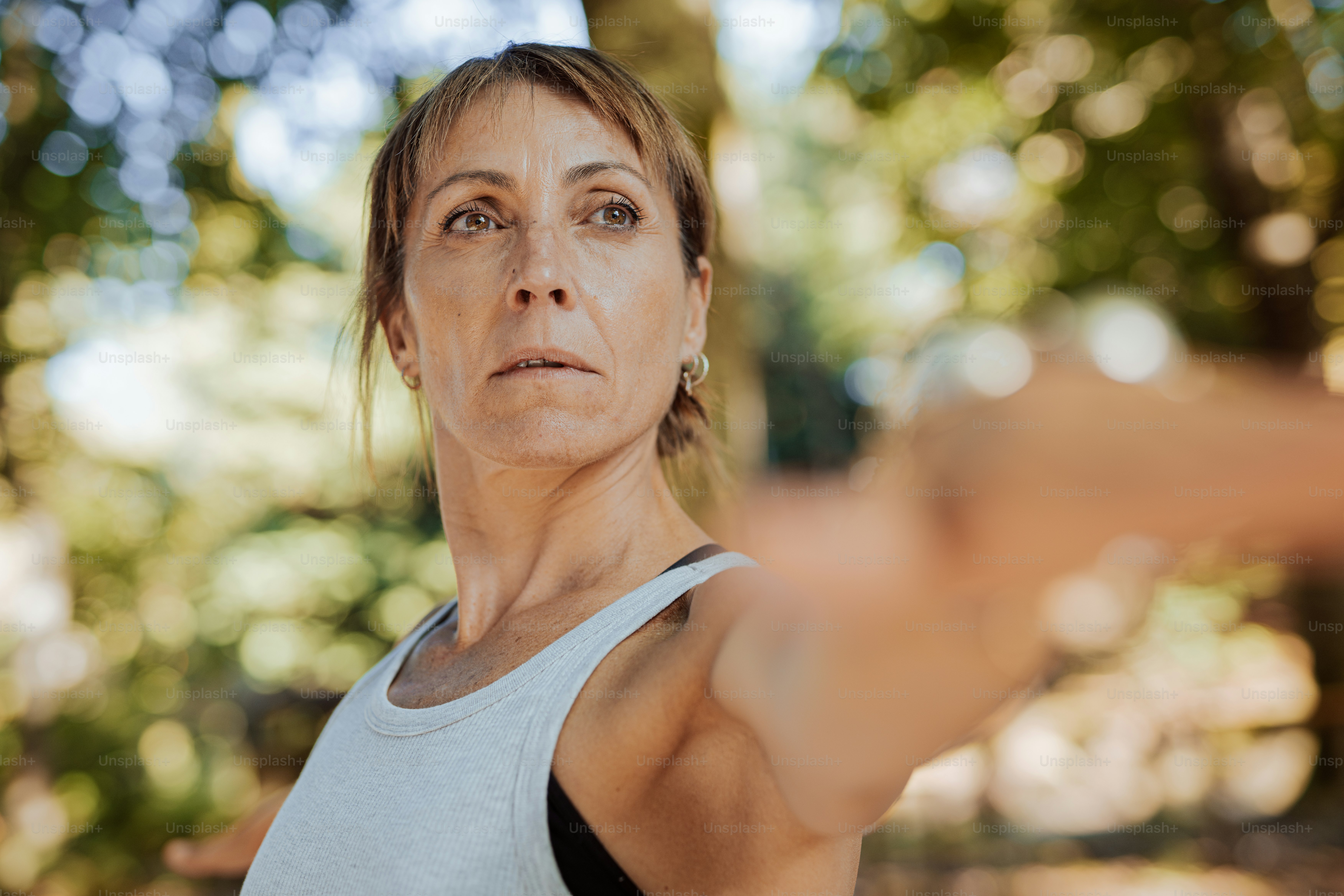 eine Frau in einem weißen Tanktop zeigt auf etwas
