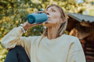 a woman drinking out of a blue cup