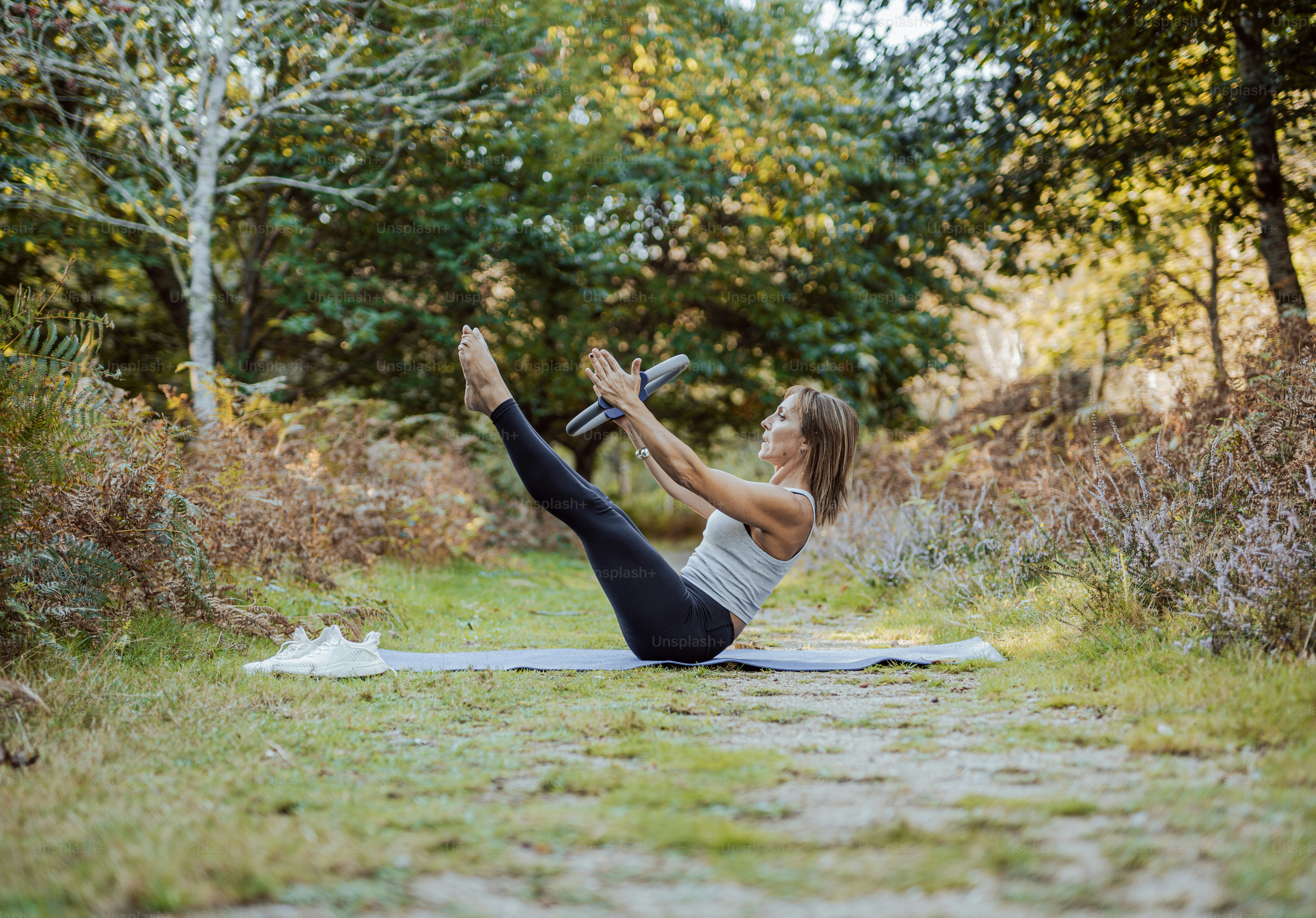Una mujer haciendo una postura de yoga en el bosque