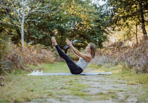 a woman doing a yoga pose in the woods