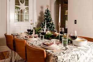 a dining room table with a christmas tree in the background