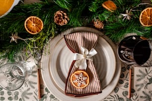 a place setting with oranges, a glass of wine and a napkin