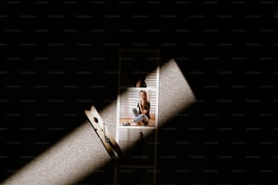 a woman sitting on a step ladder in the dark