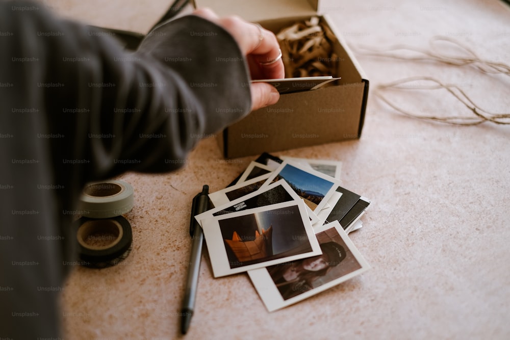 uma pessoa segurando um cartão perto de uma caixa de fotos