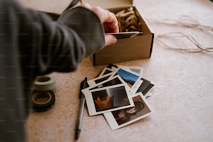 a person holding a card near a box of photos