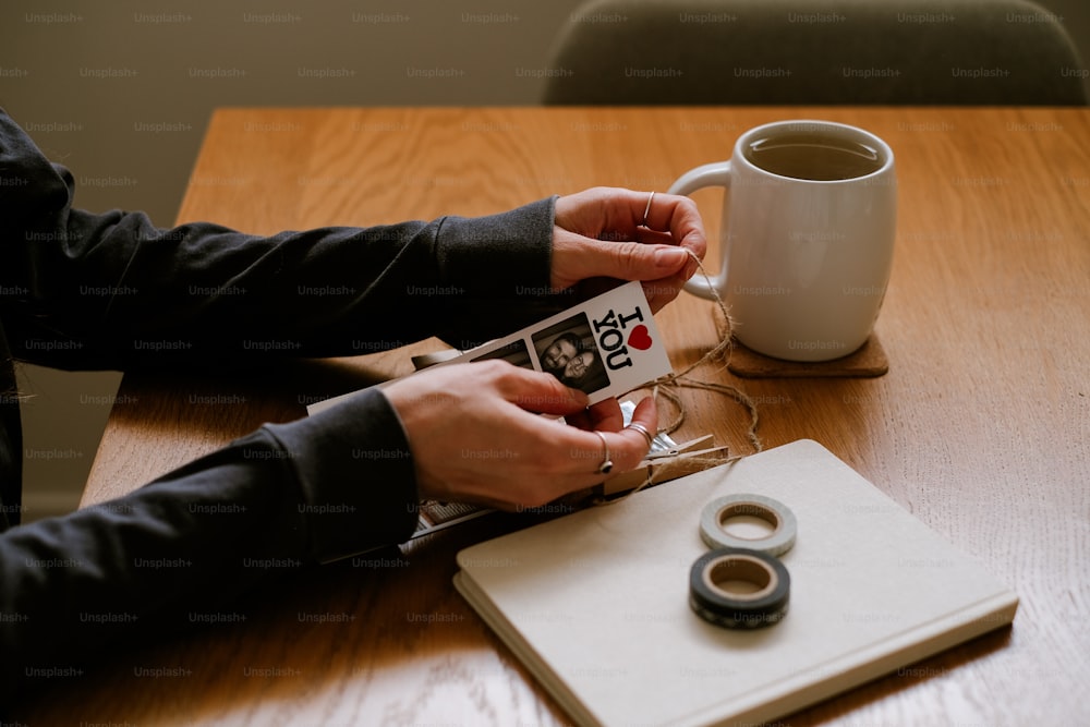 a person sitting at a table with a cup of coffee