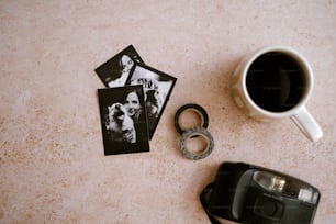 um par de fotos sentado ao lado de uma xícara de café