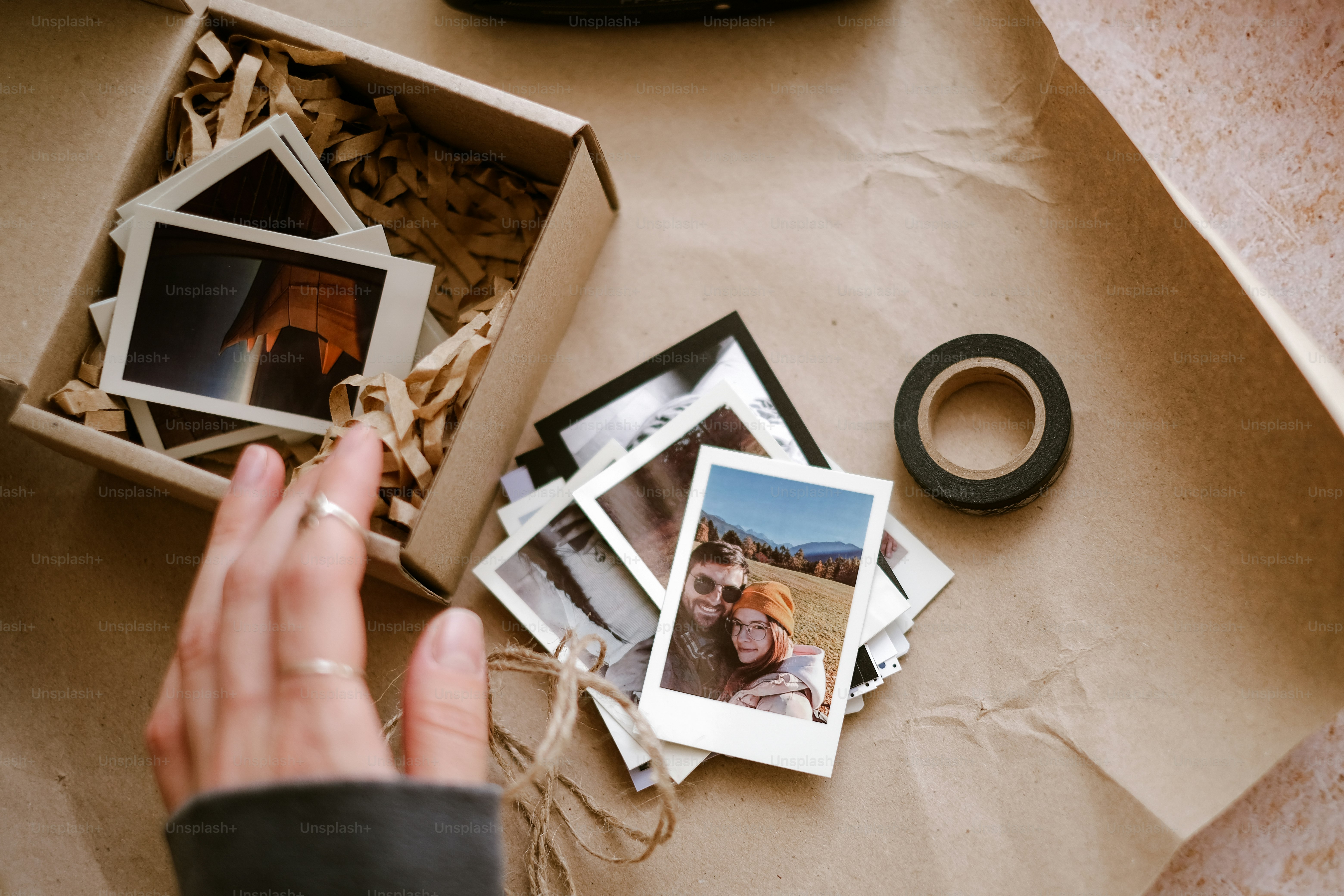 a person holding a camera near a box of photos