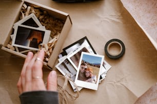 a person holding a camera near a box of photos