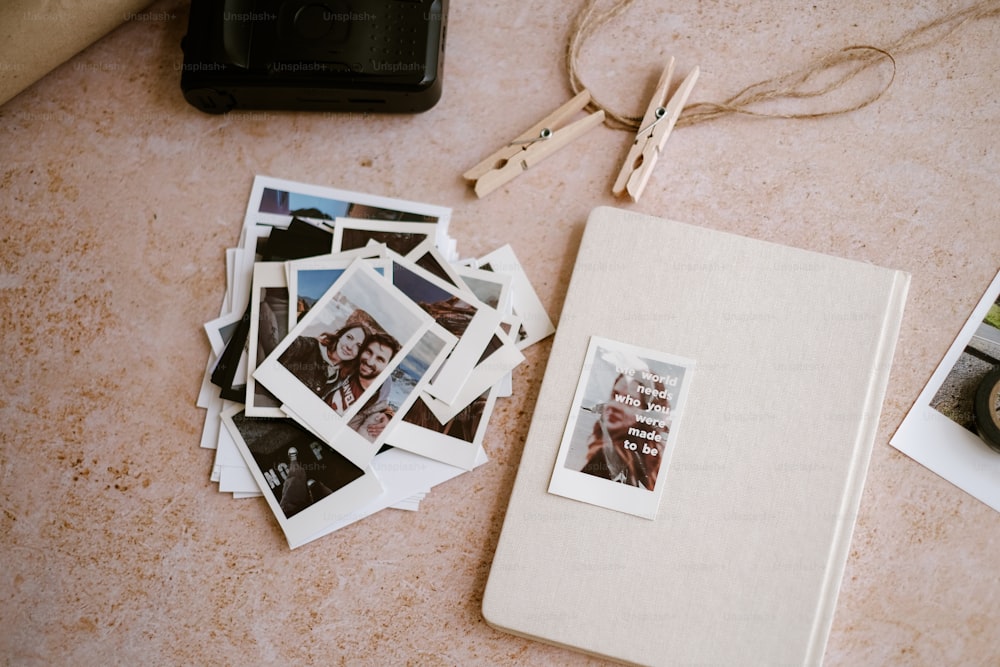 Un montón de fotos Polaroid y una cámara sobre una mesa