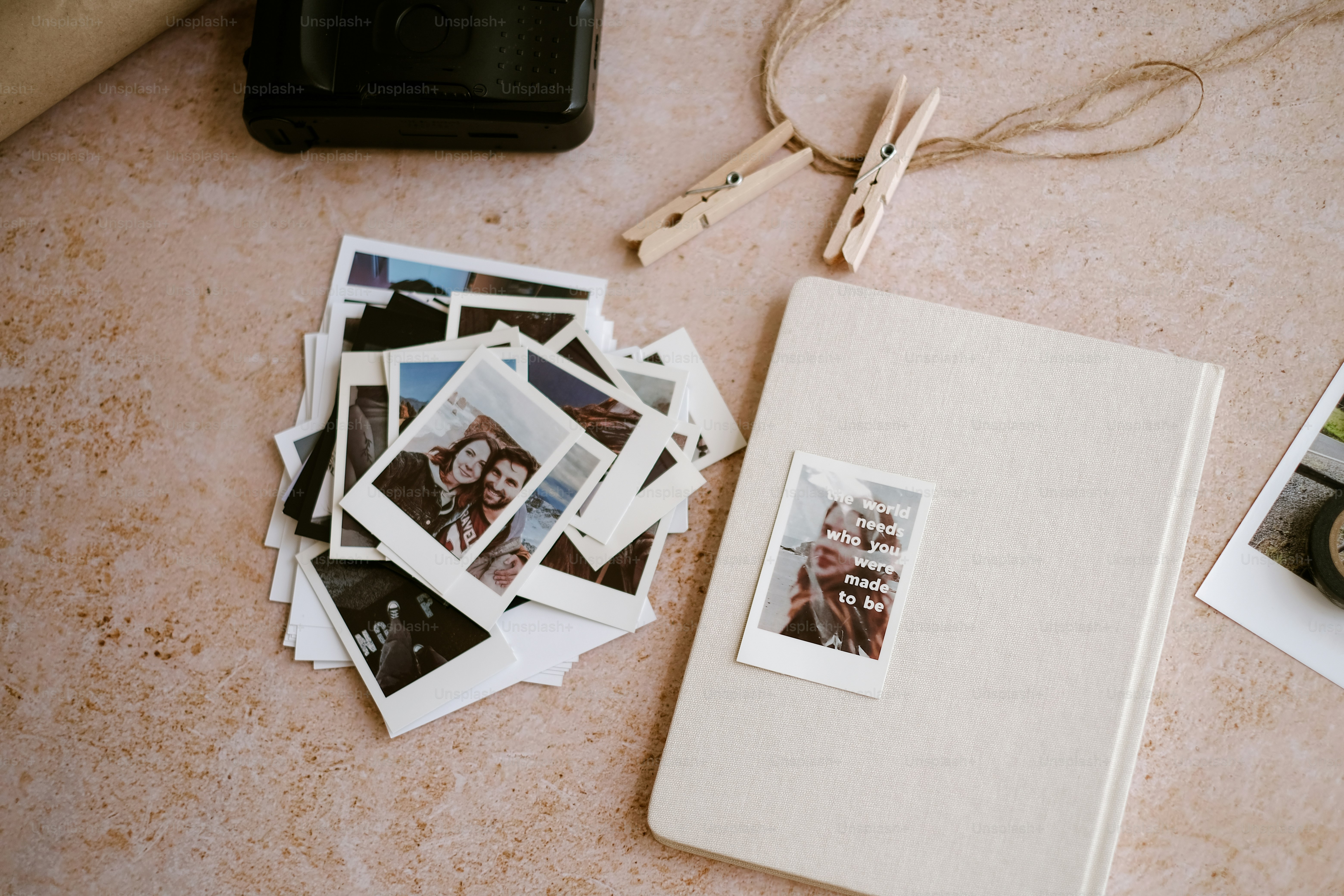 a bunch of polaroid photos and a camera on a table