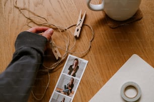 a person holding a pair of scissors next to a cup of coffee