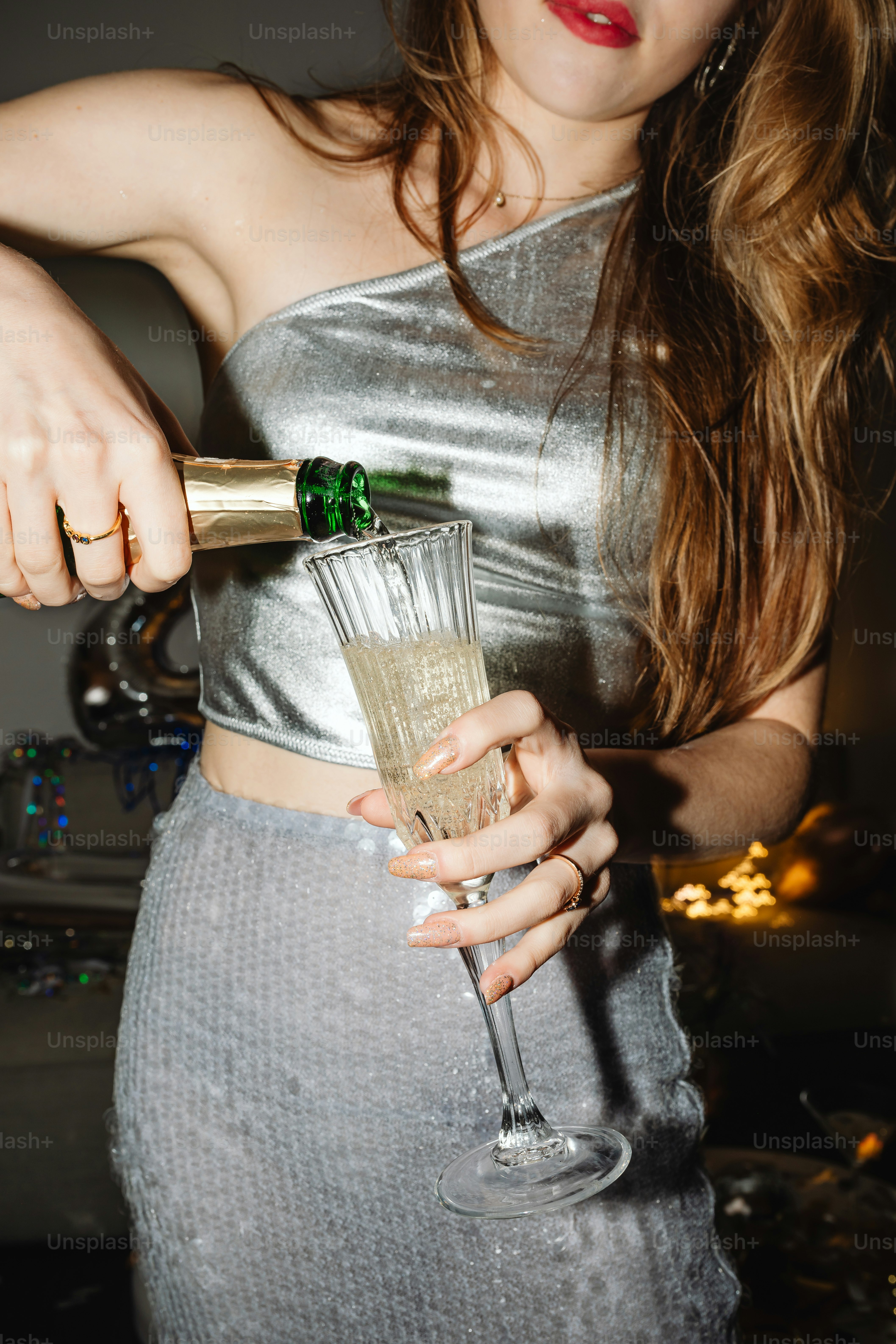 a woman in a silver dress holding a wine glass