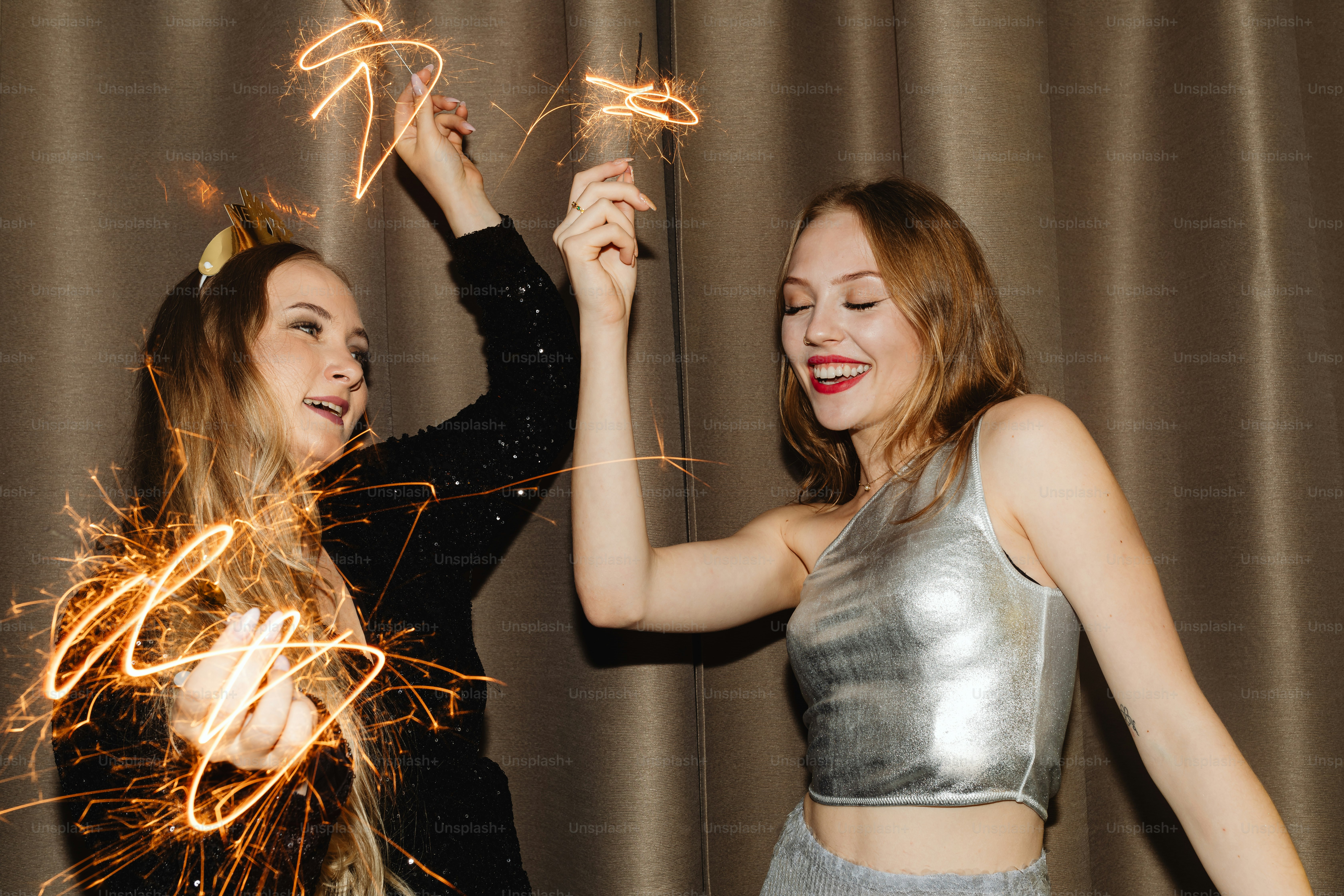 Deux jeunes femmes tenant des cierges magiques dans leurs mains