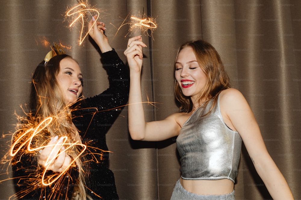two young women holding sparklers in their hands