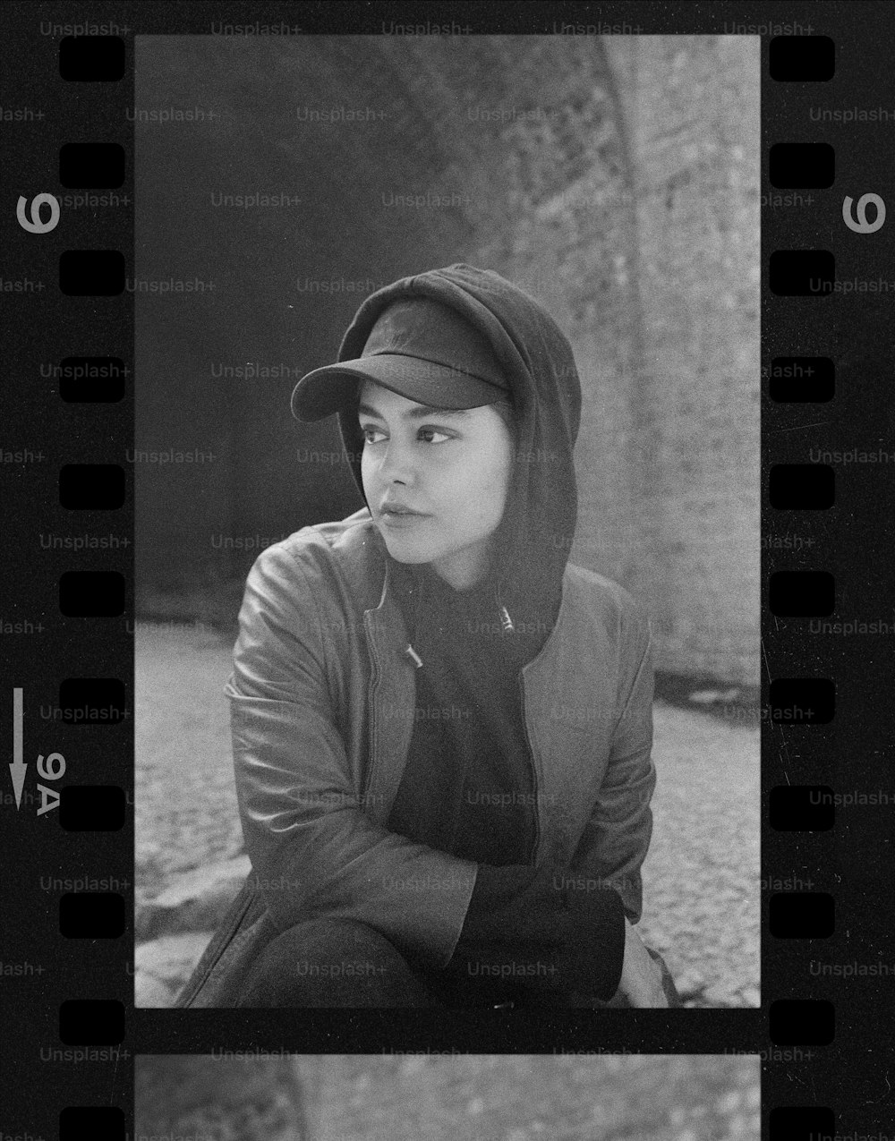 a black and white photo of a woman in a baseball cap