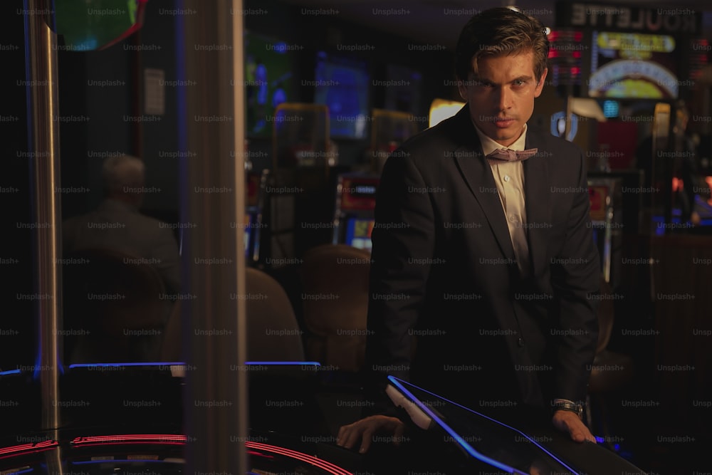 a man in a suit and bow tie in a casino