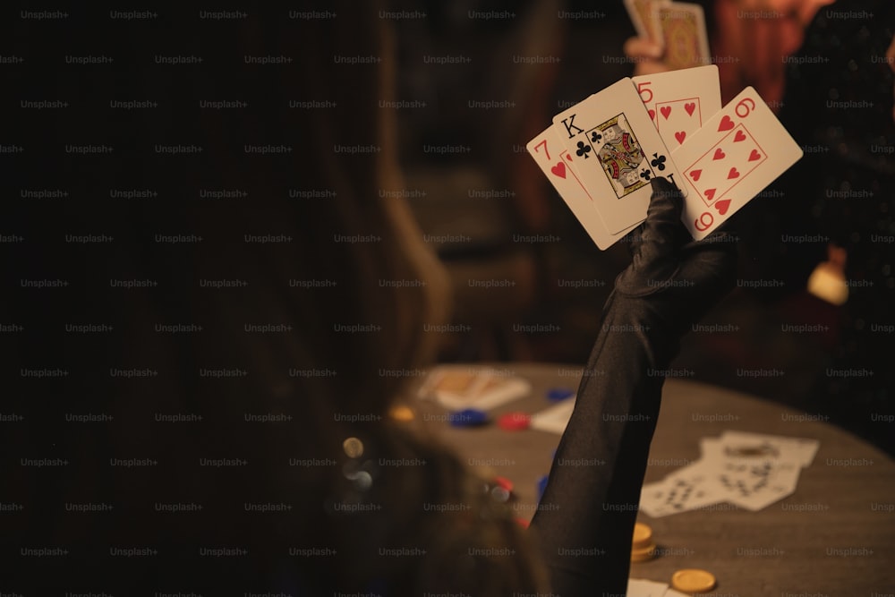 una persona che tiene in mano carte da gioco su un tavolo