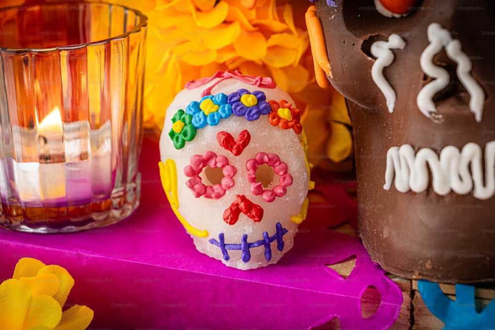 a decorated sugar skull next to a candle