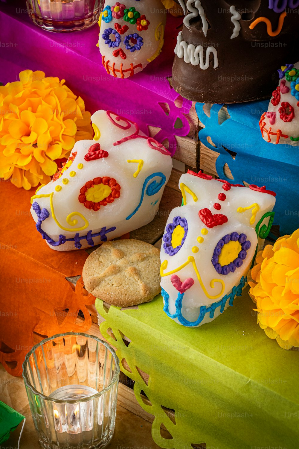 a table topped with cakes and cookies covered in frosting